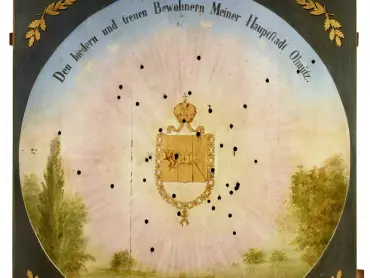 Císařský terč. 1849. Olej na dřevě 118 × 119,5 cm., signováno G. Kühn. Uprostřed plochy se nachází prsní štítek císařského orla s korunou a Řádem zlatého rouna. Dole je vyobrazena krajina s keři a stromy, připojen je nápis kurzívou – v českém překladu „13. května 1849“, při horní části kruhového obvodu je umístěna císařova dedikace „Bodrým a věrným obyvatelům Mého hlavního města Olomouce“. V rozích jsou umístěny zkřížené vavřínové a dubové snítky. Vlastivědné muzeum v Olomouci, inv. č. O-2386. Foto Pavel Rozsíval.