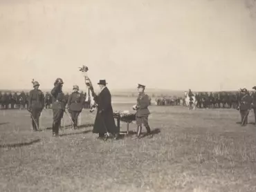Prezident T. G. Masaryk na letišti v Olomouci-Neředíně 19. září 1921 předává prapor veliteli 2. sibiřskému jízdnímu pluku plukovníku Jaroslavu Červinkovi; za prezidentem stojí u stolku divizní generál Josef Kroupa. Fotografie, Státní okresní archiv v Olomouci, Archiv města Olomouce, fond Sbírka obrazového materiálu a fotografií Olomouc, M 8-34, inv. č. 1871.